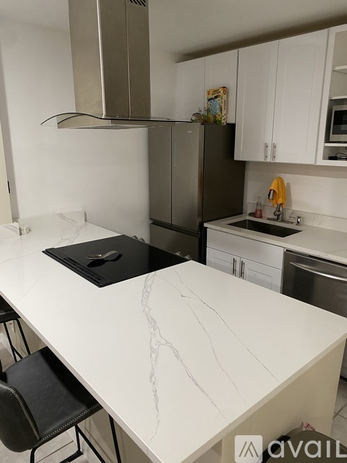 A kitchen with a marble countertop and stainless steel appliances.