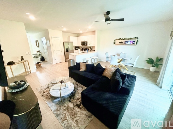 A living room with a black couch and a coffee table.