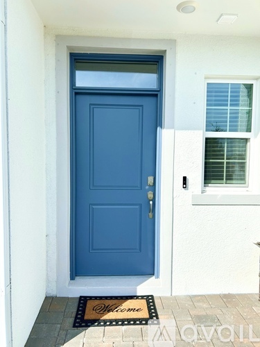 A blue door with a mat that says Welcome.