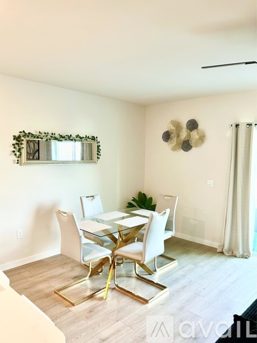 A dining room with a glass table and white chairs.