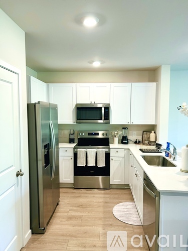 A kitchen with white cabinets and a stainless steel refrigerator.