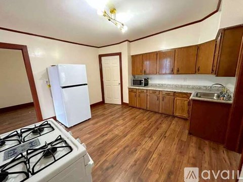 A kitchen with a white gas stove and wooden floors.