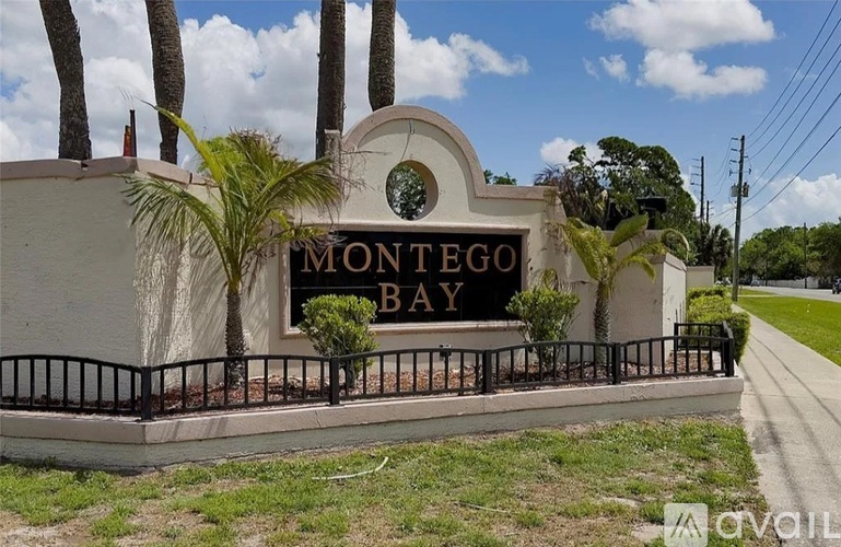 A sign that says Montego Bay in front of some trees.