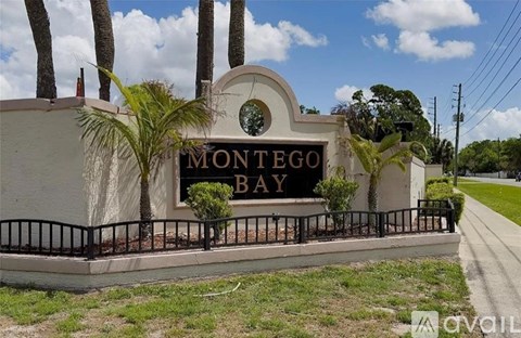 A sign that says Montego Bay in front of some trees.
