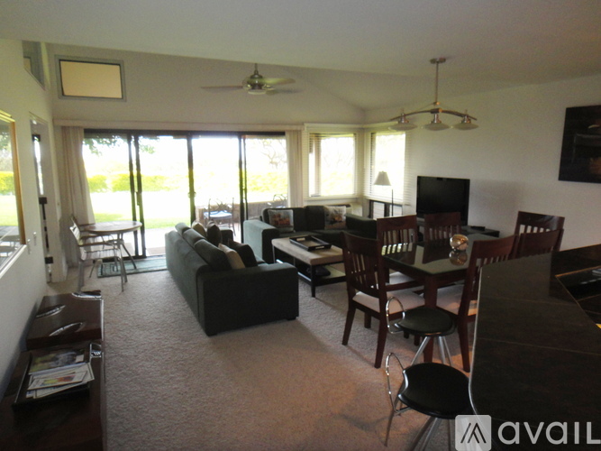 A living room with a couch, chairs, and a television.