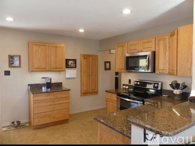 A kitchen with wooden cabinets and granite countertops.