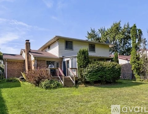 A house with a front yard and a tree.