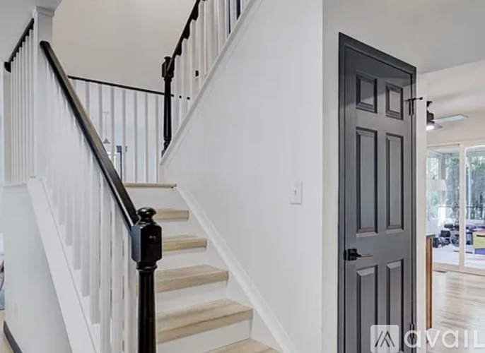 A staircase with a black railing and a black door.