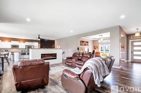 A living room with brown leather couches and a fireplace.