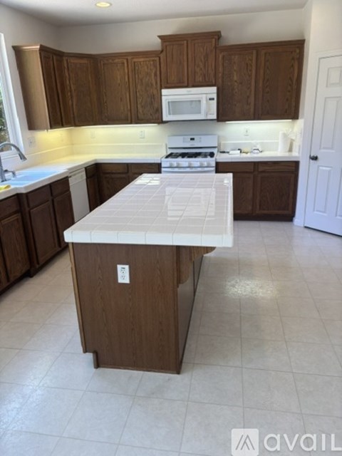 A kitchen with brown cabinets and a white island.