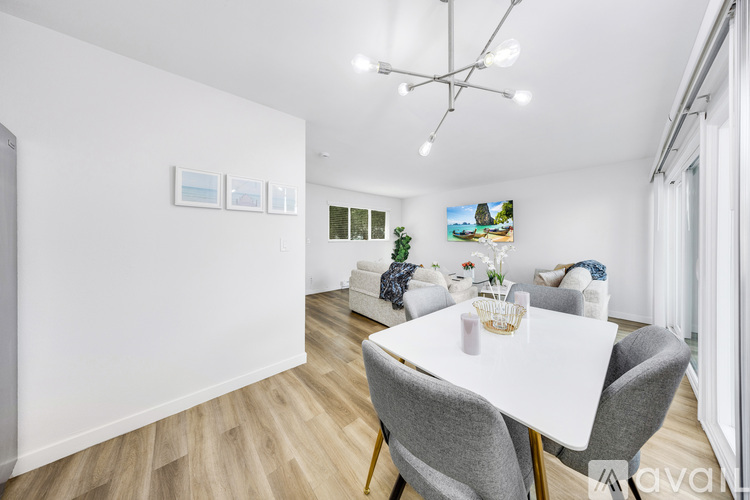 A dining room with a white table and grey chairs.