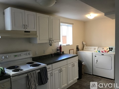 A kitchen with white cabinets and a black countertop.
