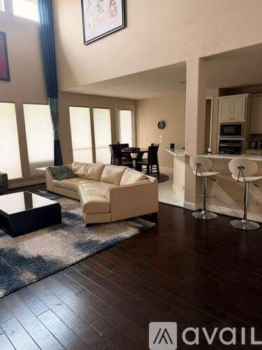 A living room with a white couch and a black coffee table.