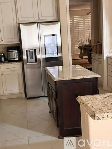 A kitchen with a refrigerator and microwave built into the cabinetry.