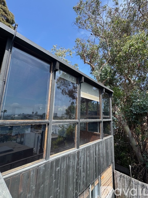 A building with a large window reflecting the sky and trees.