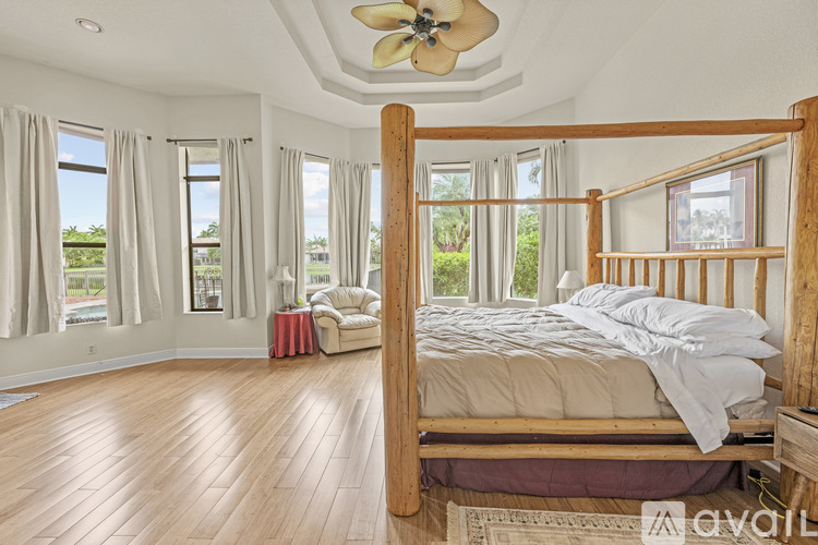 A bedroom with a large bed and a ceiling fan.