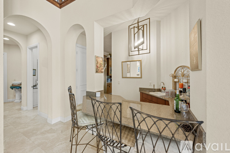 A kitchen with a bar area and a dining table with chairs.