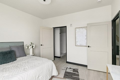 A bedroom with a large bed and a white door.