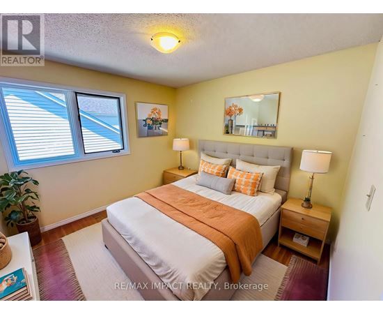 A bedroom with a bed, two lamps, and a potted plant.
