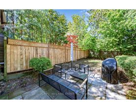 A backyard with a wooden fence and a bench.