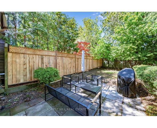 A backyard with a wooden fence and a bench.