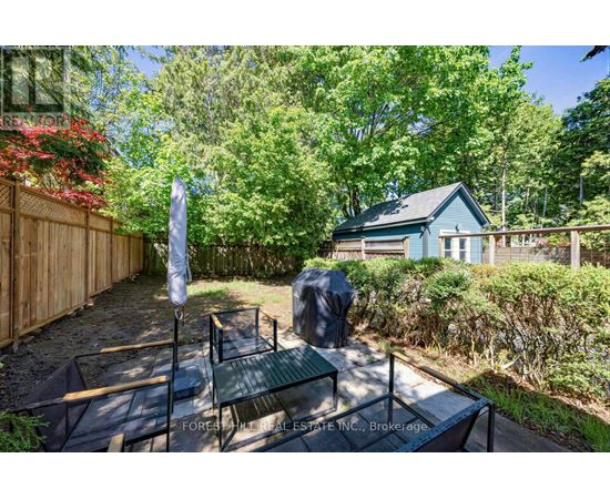A backyard with a table and chairs and a blue house in the background.
