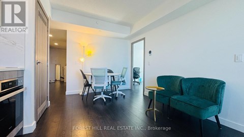 A living room with a green couch and a bar stool.