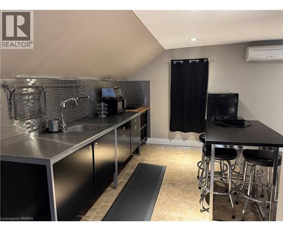 A kitchen with a black countertop and stainless steel appliances.