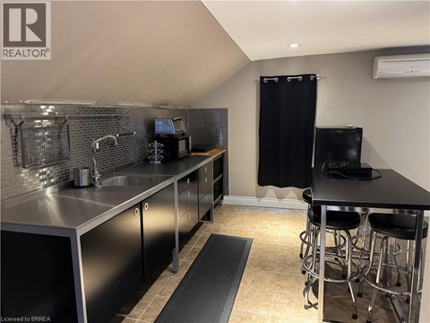 A kitchen with a black countertop and stainless steel appliances.