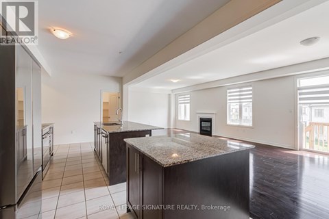A spacious kitchen with dark wood cabinets and a granite countertop.