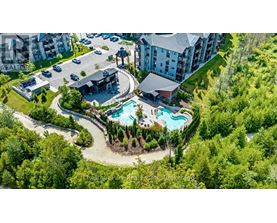 A bird's eye view of a resort with a swimming pool and a parking lot.