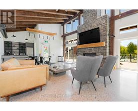 A living room with a stone fireplace and a flat screen TV.