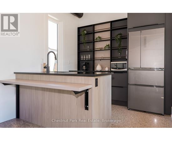 A modern kitchen with a wooden countertop and stainless steel appliances.
