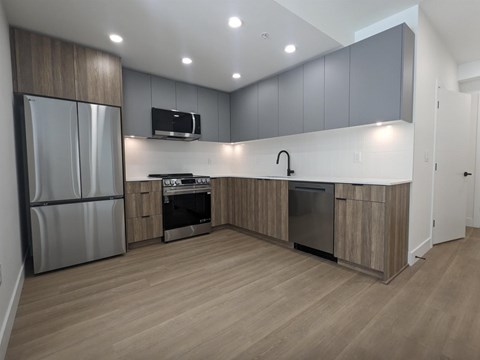 A modern kitchen with wooden cabinets and stainless steel appliances.