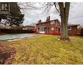 A house with a red brick exterior and a green lawn.