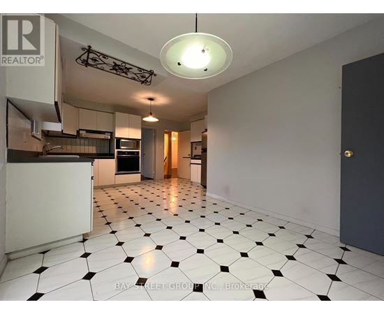 A spacious kitchen with black and white tiled flooring.