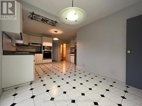 A spacious kitchen with black and white tiled flooring.