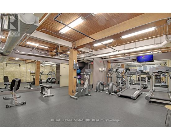 A gym with a variety of equipment including treadmills, weights, and exercise machines.