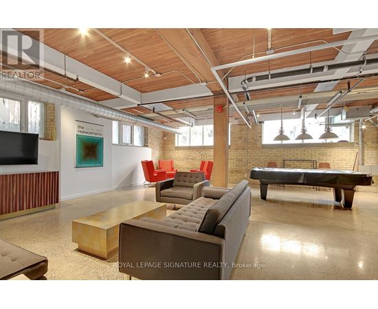 A large room with a pool table and couches.