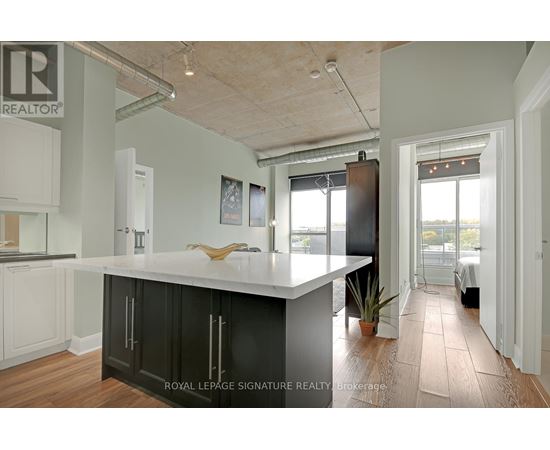 A kitchen with a white counter top and black cabinets.
