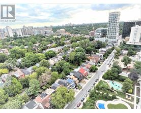 A bird's eye view of a residential area with a swimming pool and a tall building in the distance.