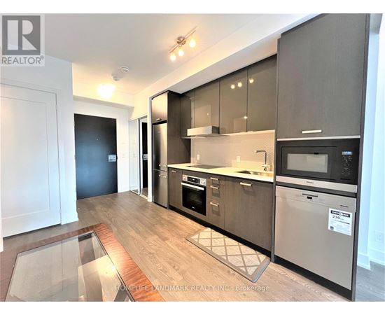 A modern kitchen with dark wood cabinets and stainless steel appliances.