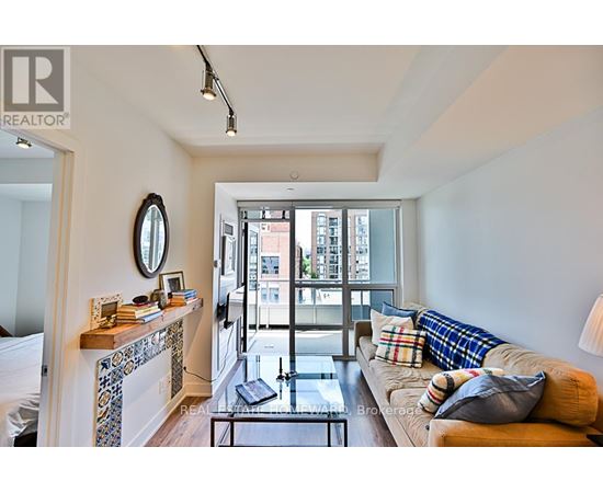 A living room with a couch, a coffee table, and a fireplace.