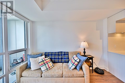 A living room with a tan couch and a small black table.