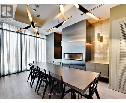 A modern dining room with a long table and chairs.