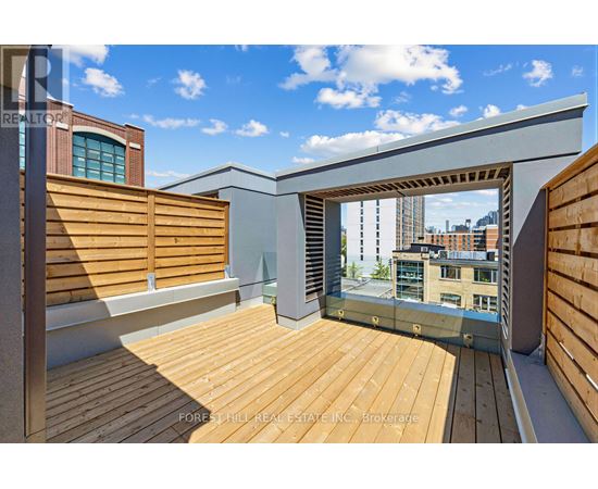 A wooden deck with a glass railing and a view of the city.