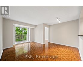A room with wooden flooring and a sliding glass door leading to a balcony.