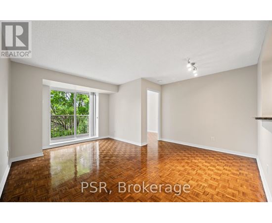 A room with wooden flooring and a sliding glass door leading to a balcony.
