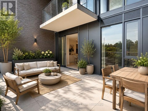 A modern outdoor patio with a sofa, chairs, and a table.