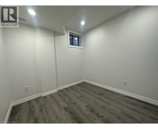 A room with wooden flooring and white walls.
